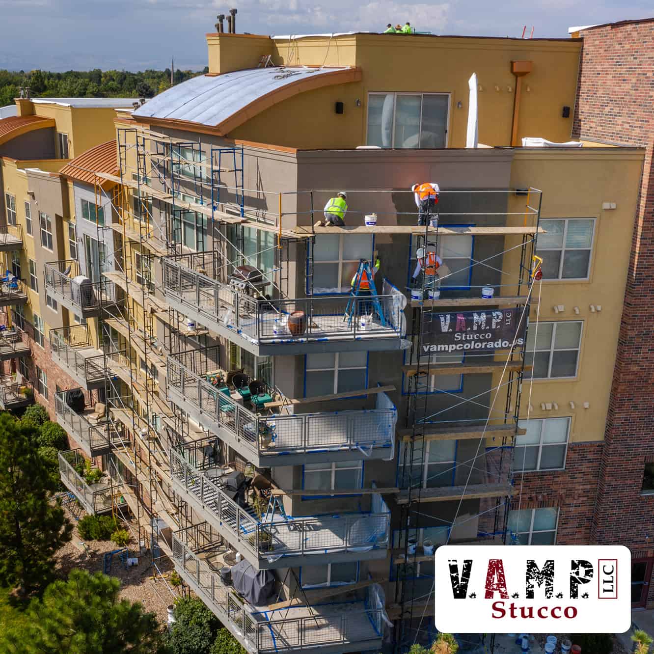 Business Owners Choose V.A.M.P. Stucco: Multi-family building under construction with skilled craftsmen installing high-quality stucco, showcasing V.A.M.P. Stucco's commitment to excellence and craftsmanship in commercial property development.