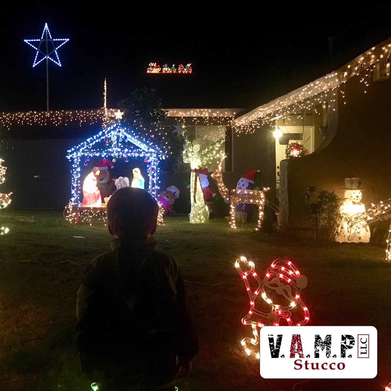 Toddler marveling at outdoor Christmas lights on a well-maintained stucco home, illustrating V.A.M.P. Stucco's expert advice on holiday decorating without damaging your exterior.